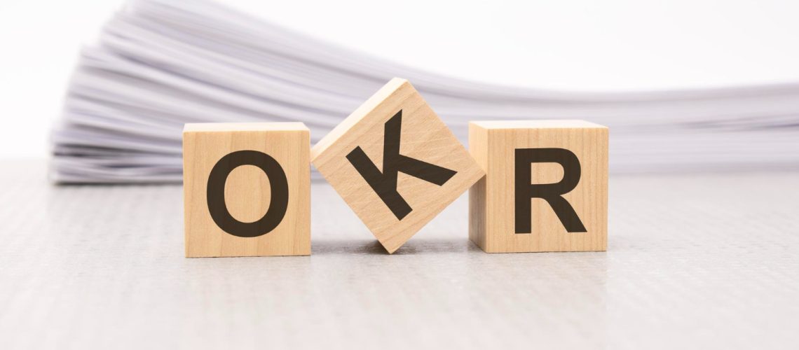 wooden-block-with-text-okr-acronym-objectives-key-results-wooden-blocks-are-paper-white-background-business-concept-front-view